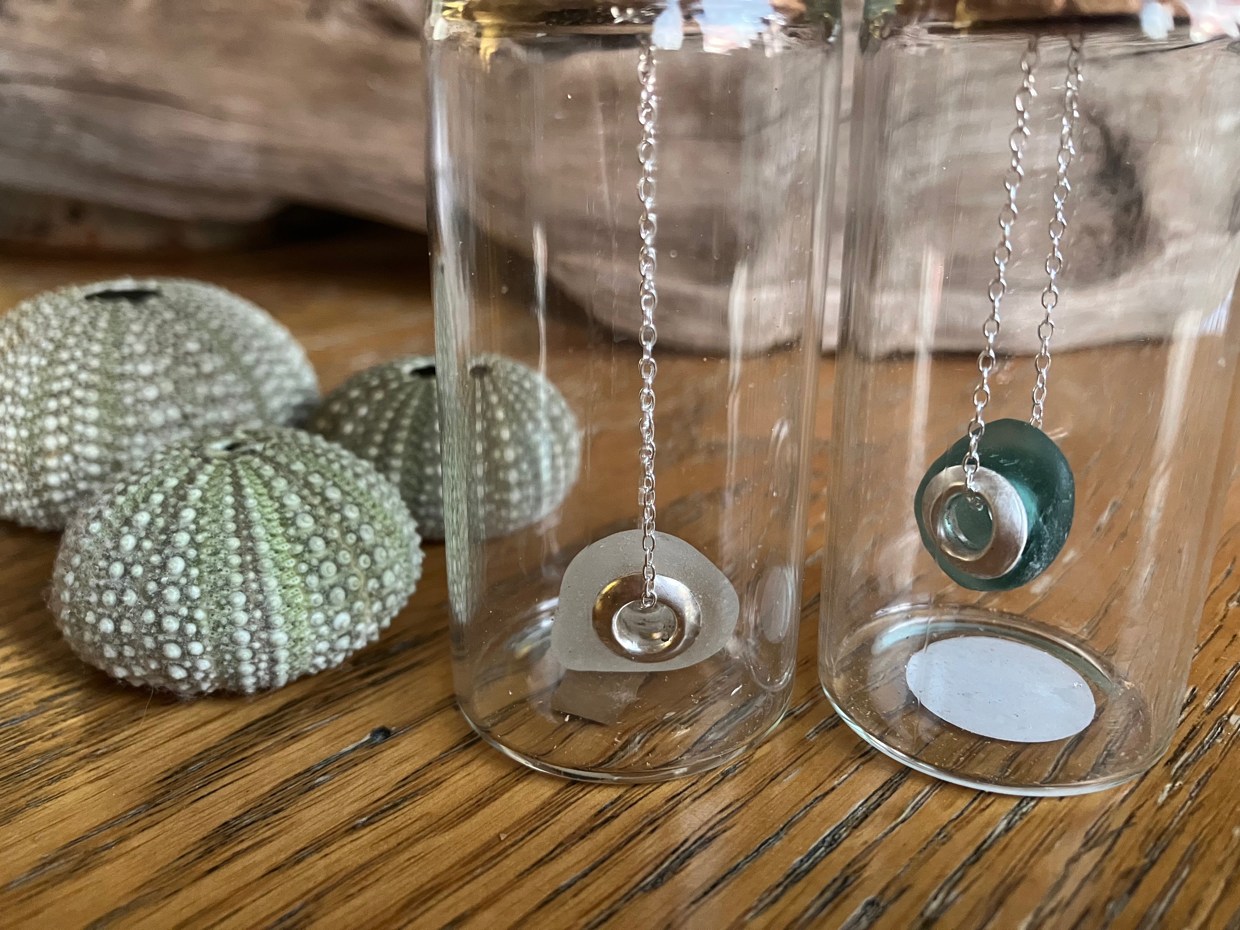 Silver chain necklace with teal glass bead and silver circular pendant