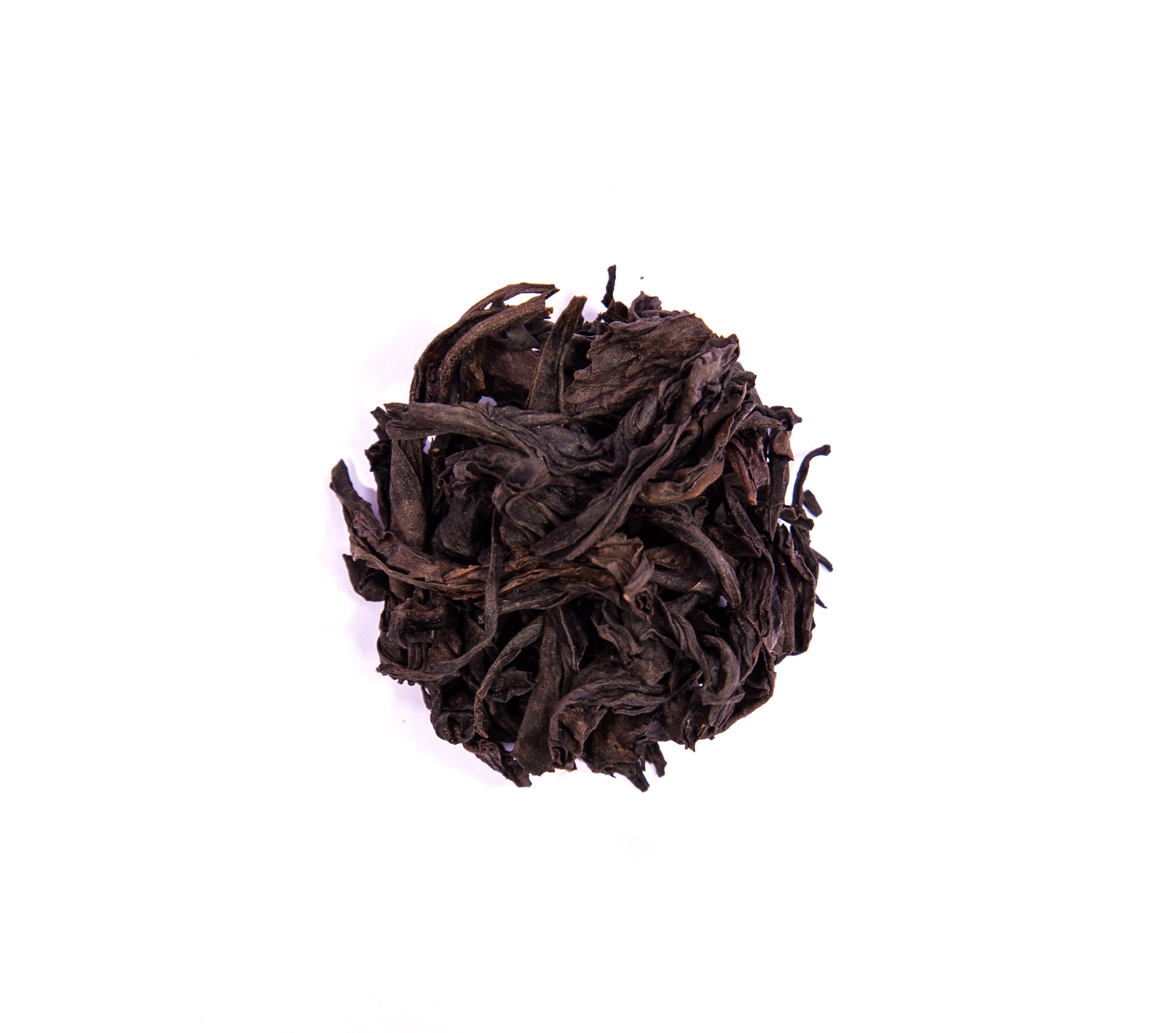 A dark tightly curled mound of dried tea leaves in zhou family handmade wuyi da hong pao tea product