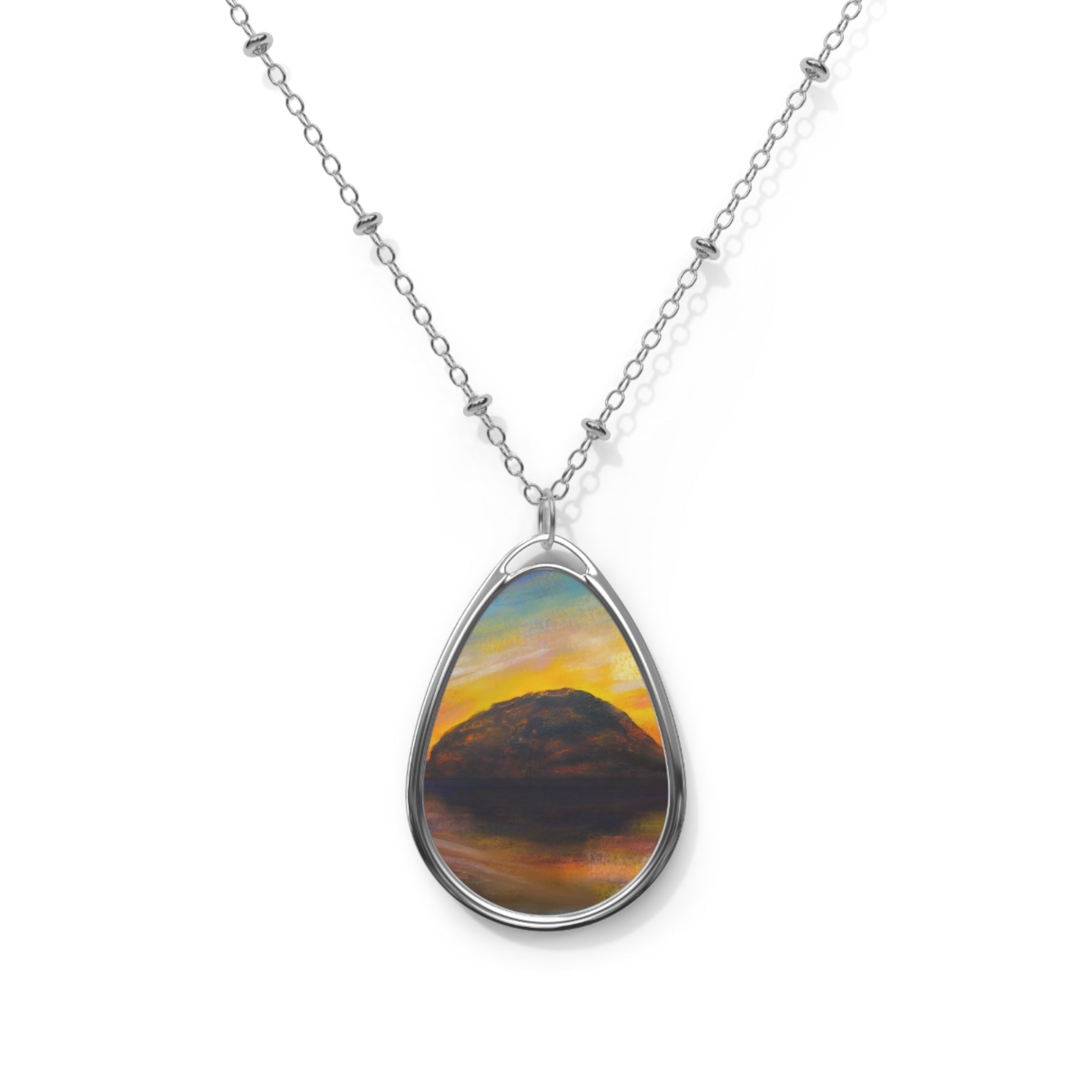 Silver chain necklace with an oval pendant featuring a painted sunset landscape from Ailsa Craig Dusk collection