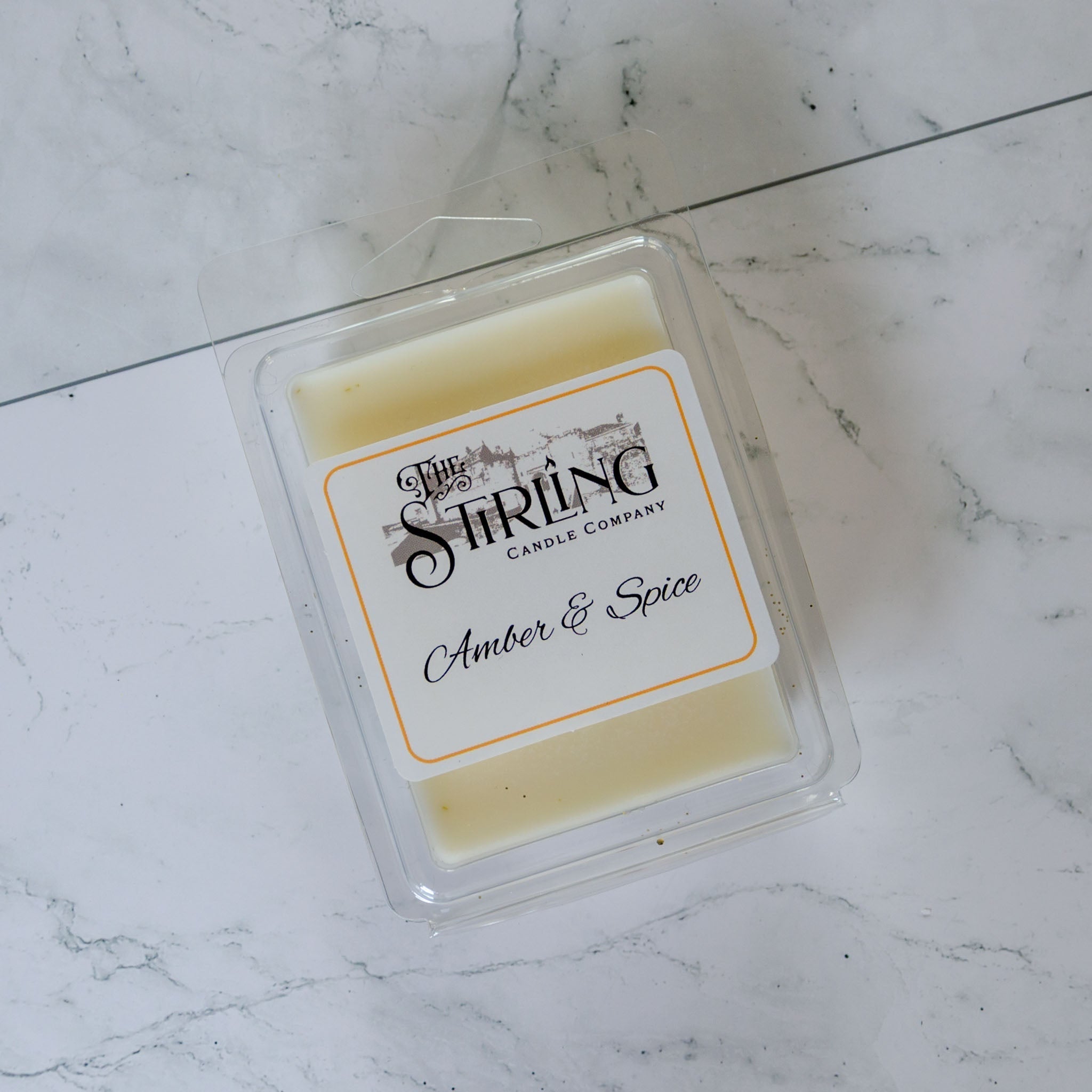 Amber & Spice wax melt clamshell in pale yellow wax with orange label