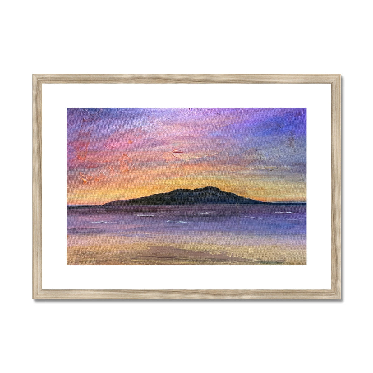 A framed Arran amethyst art print of a sunset over water with an island in purples pinks and golds in a light wood frame
