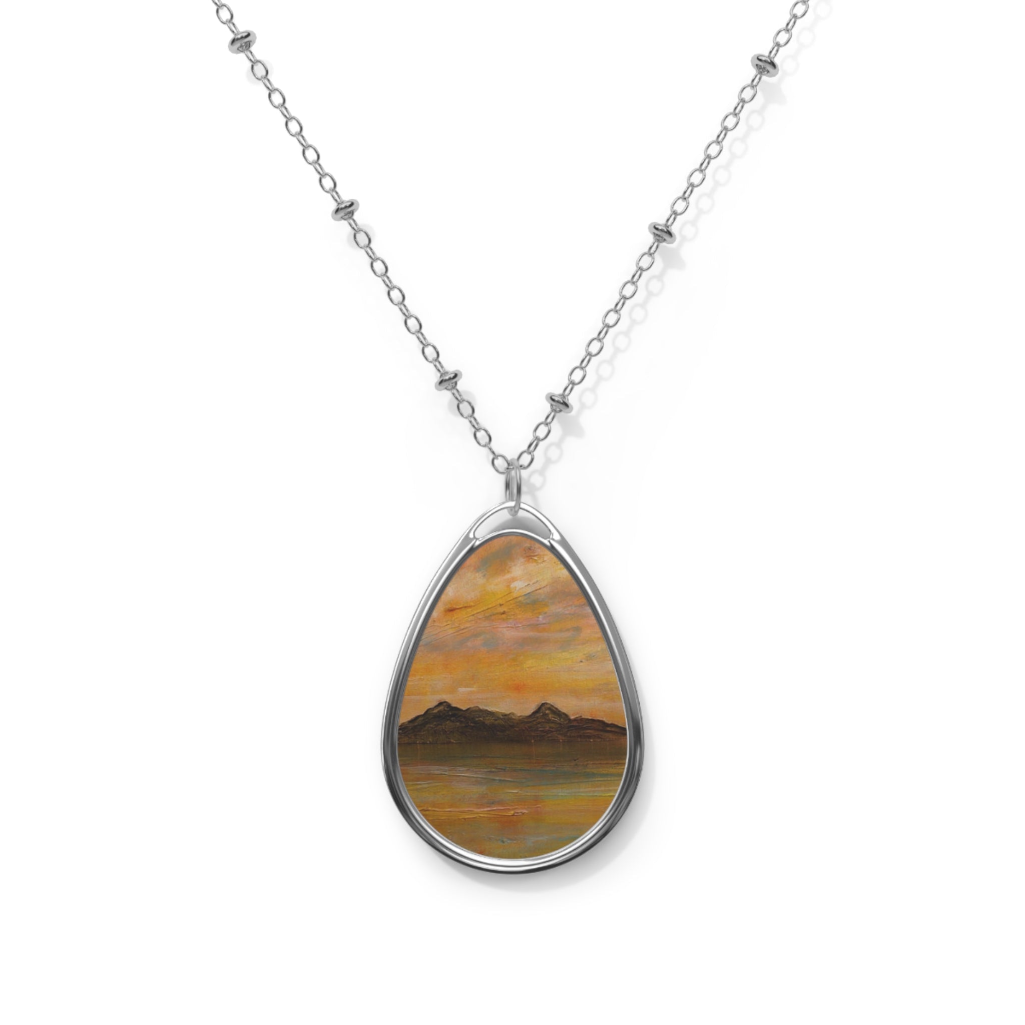 Silver chain necklace with oval pendant featuring a mountain and water sunset landscape