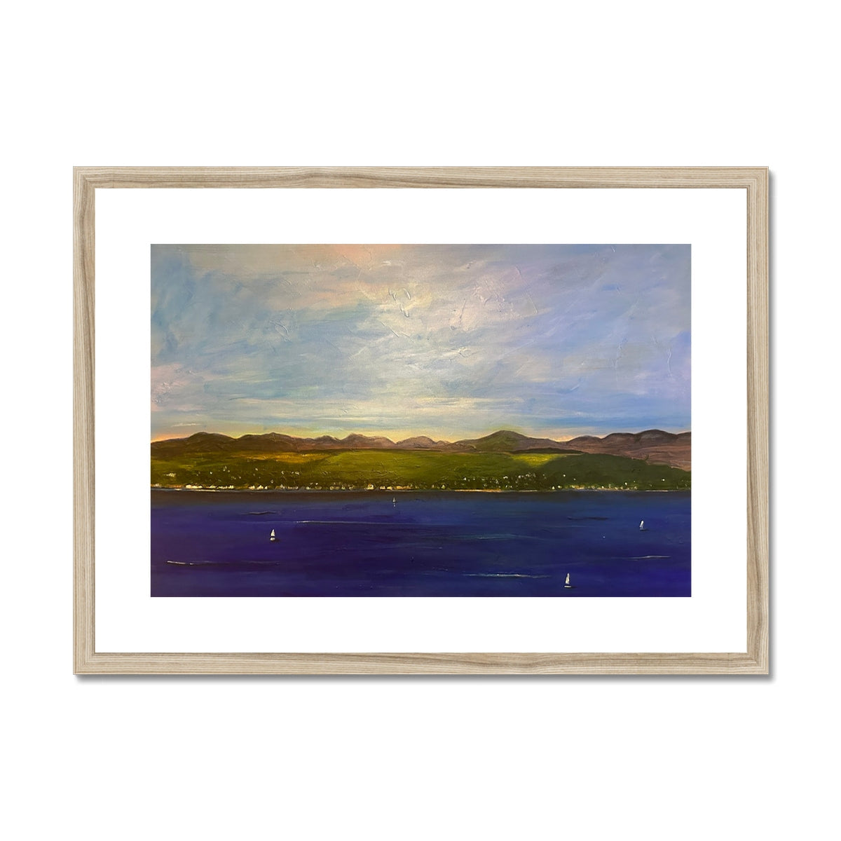 Framed landscape print of a serene bay with mountains, town, sailboats, and cloudy sky