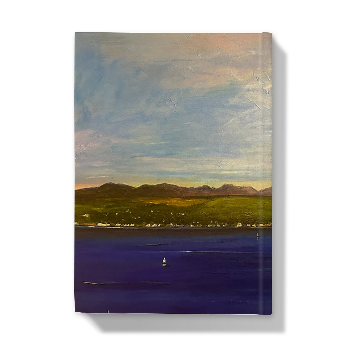 Vibrant impressionistic landscape painting of a lake, mountains, and a small town on The Biggie Hardback Journal