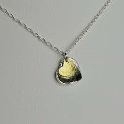 Delicate silver chain with two-toned brass heart pendant, gold center and black edge