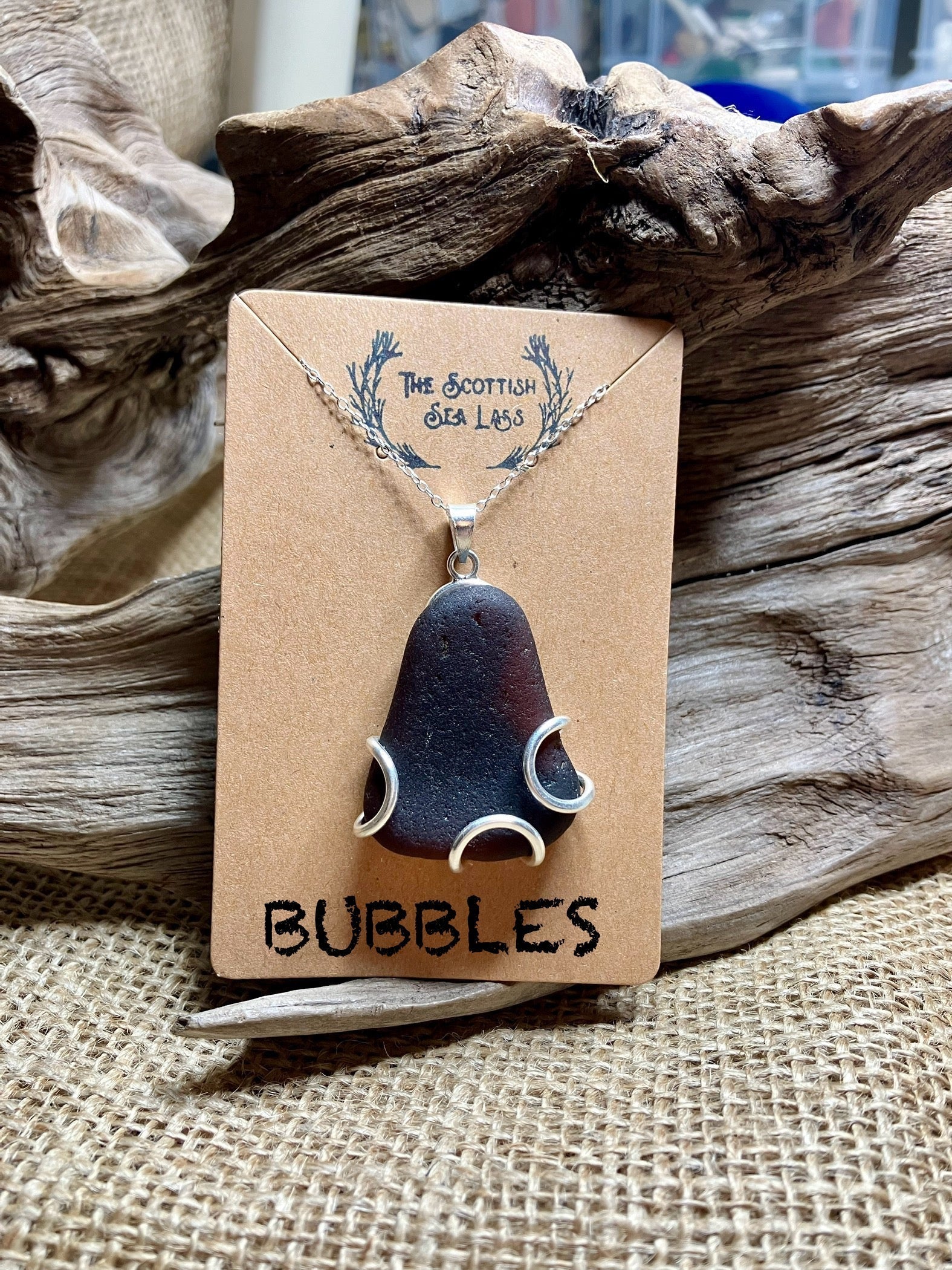 Dark brown Scottish Seaglass pendant with silver wire accents on a silver chain