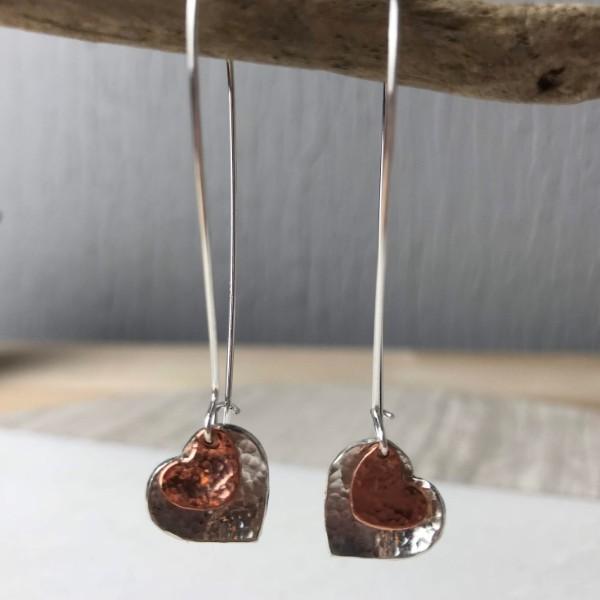 Silver and copper heart earrings with hammered texture in a drop style perfect for everyday wear