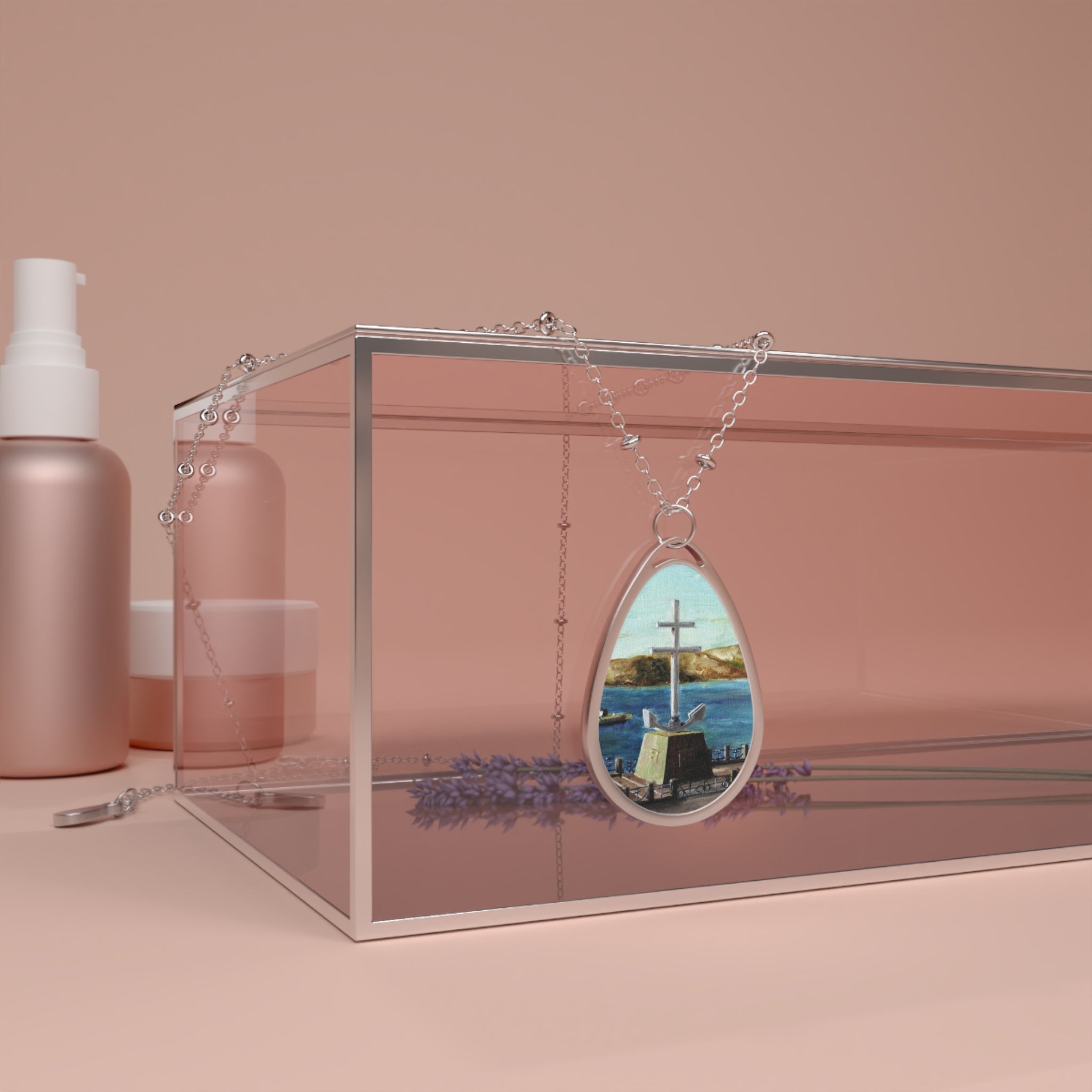 Silver teardrop pendant with colorful cross image on stone near water and hills