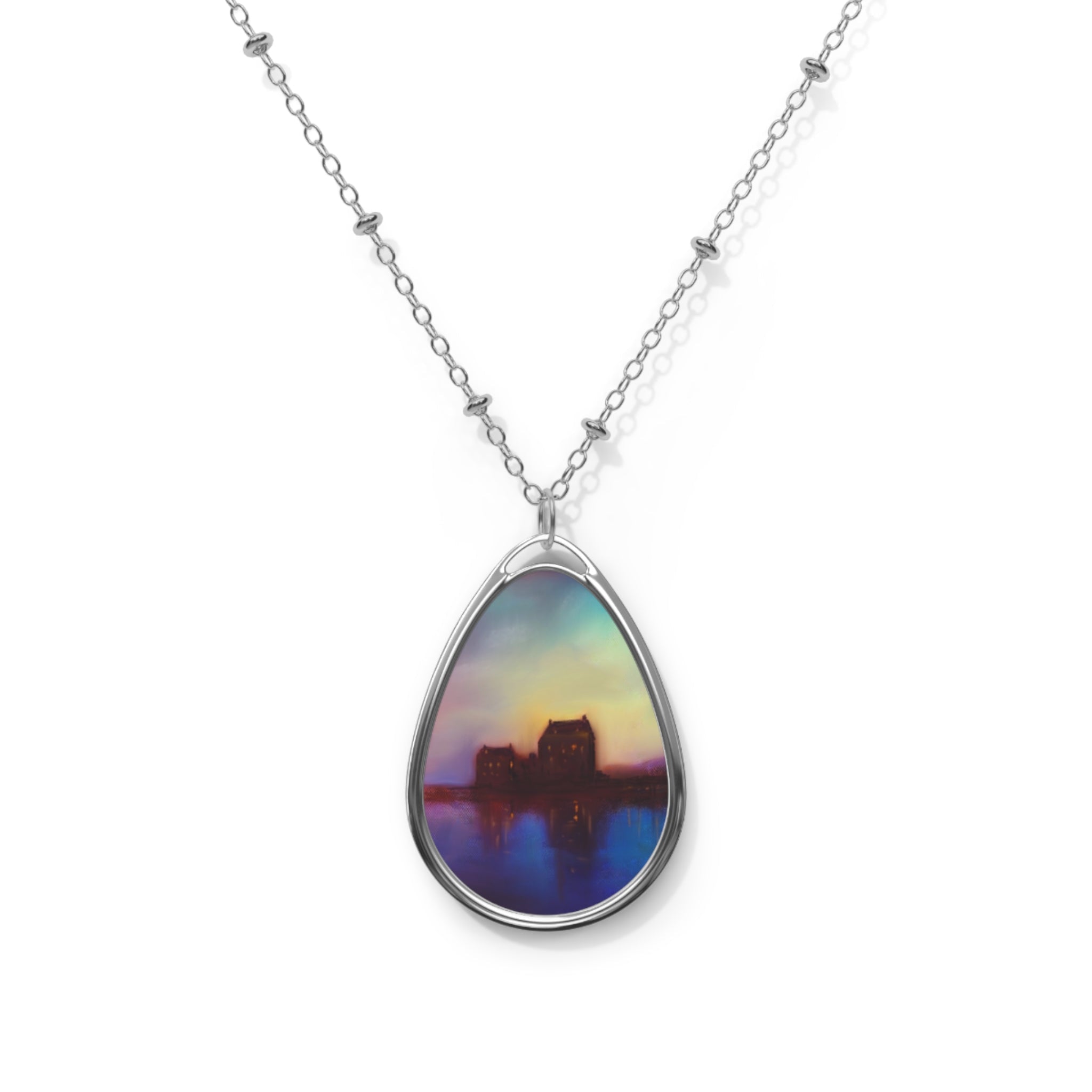 Silver chain necklace with oval pendant featuring a colorful dusk cityscape painting