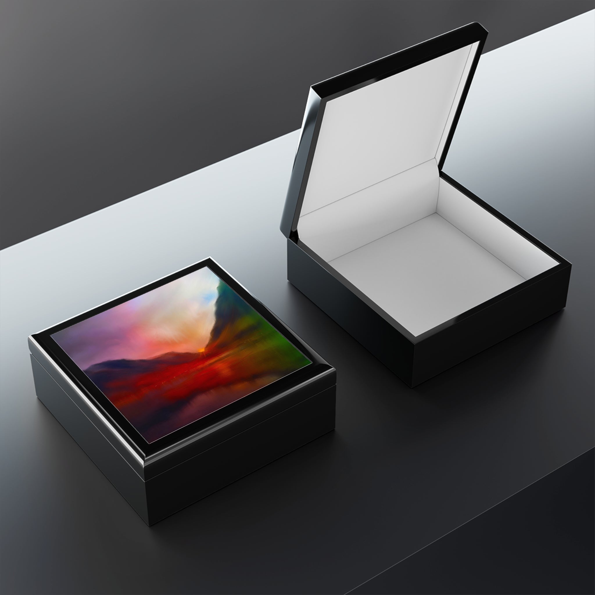 Black lacquered Glencoe Sunset jewellery boxes, one open with white interior, one closed with colorful abstract lid