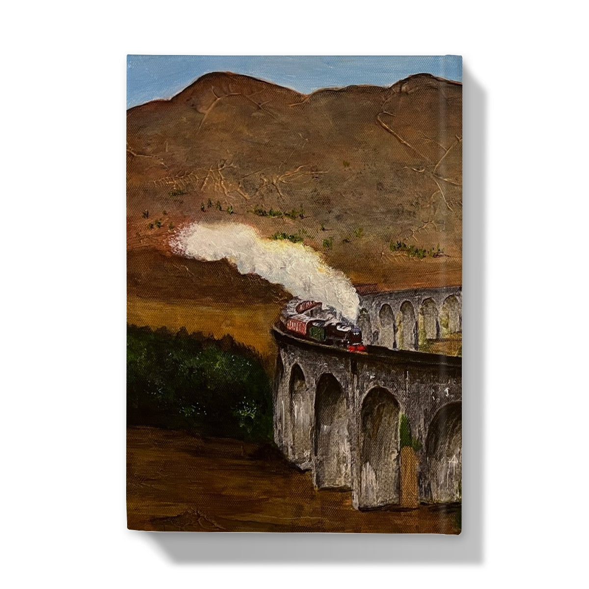 Painting of a steam train on Glenfinnan Viaduct amid mountains on the journal cover