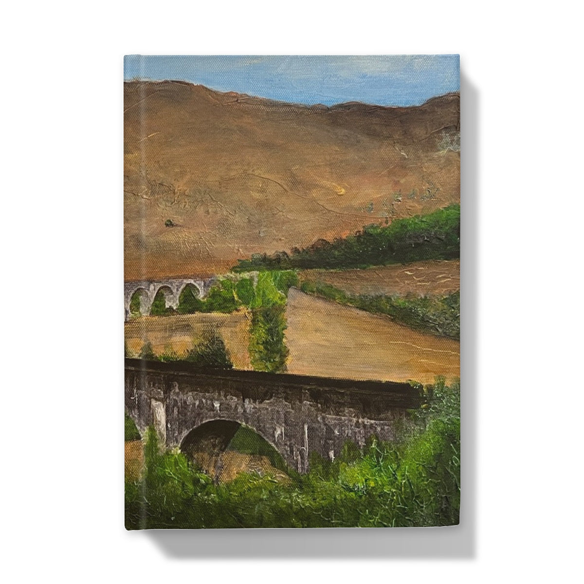 Vibrant landscape painting of rolling hills, fields, and stone bridges on Glenfinnan Viaduct Journal