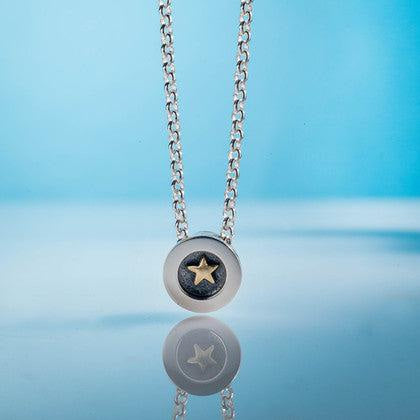 Gold Star Pendant: silver necklace with centered gold star on dark metal