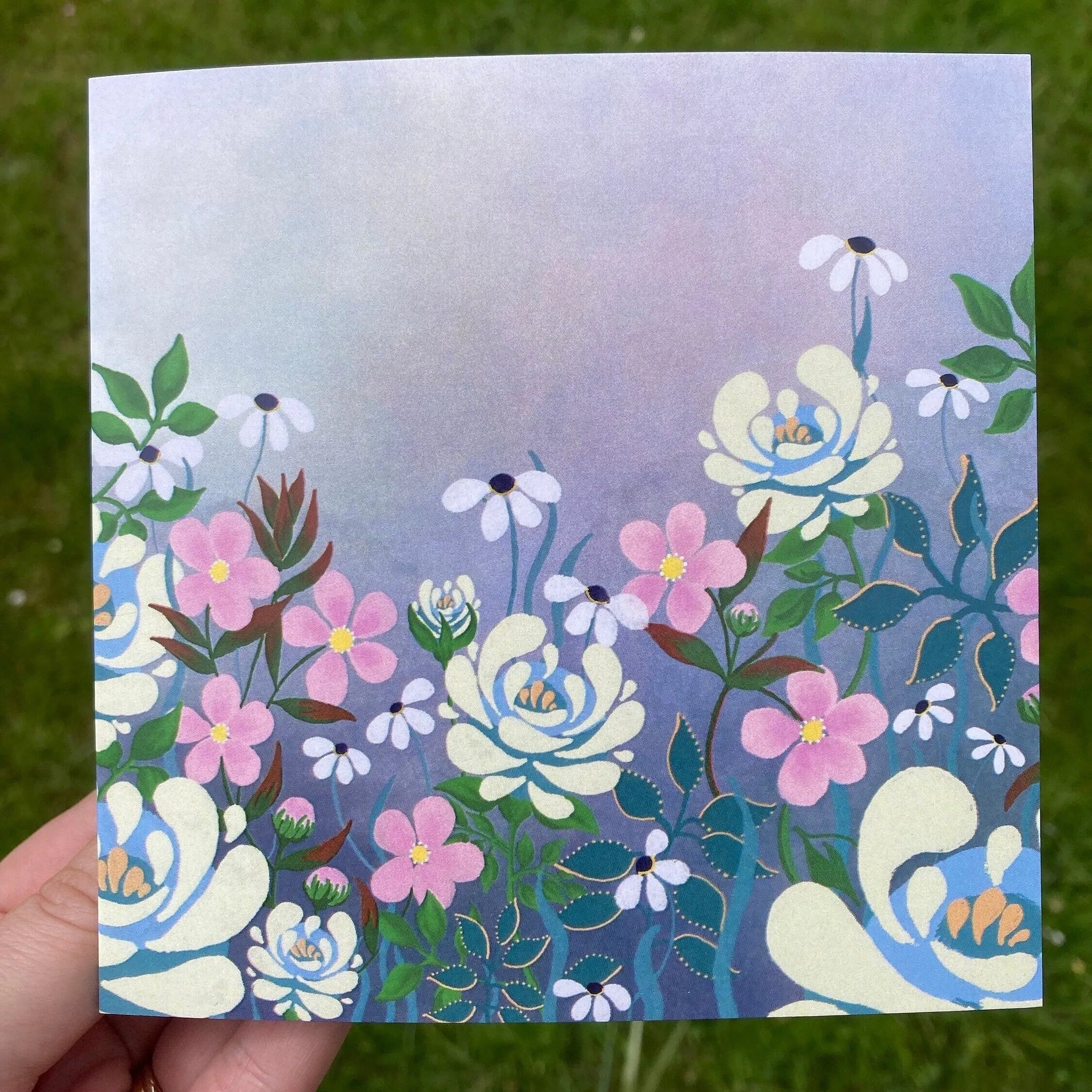 Square greeting card with vibrant floral illustration of Ivory, Pink Roses, and Daisies on a soft purple and blue background