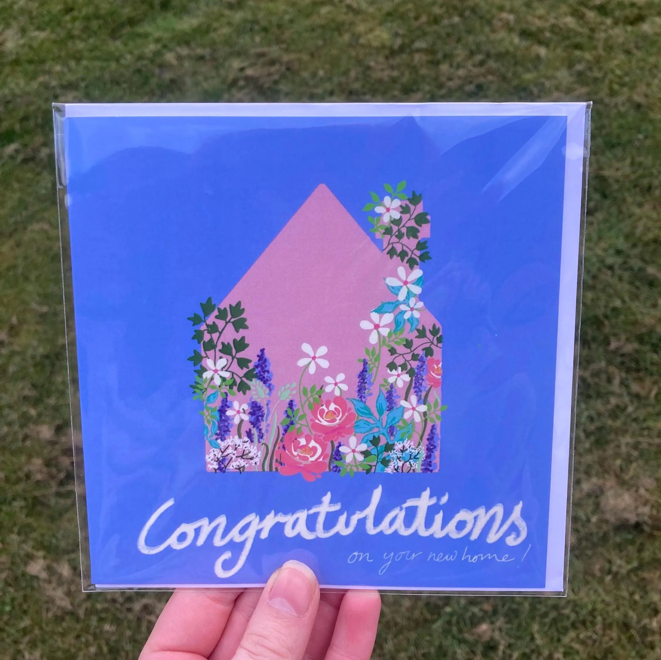 Hand-Drawn New Home Square Greetings Card featuring a pink house and colorful flowers in clear plastic packaging