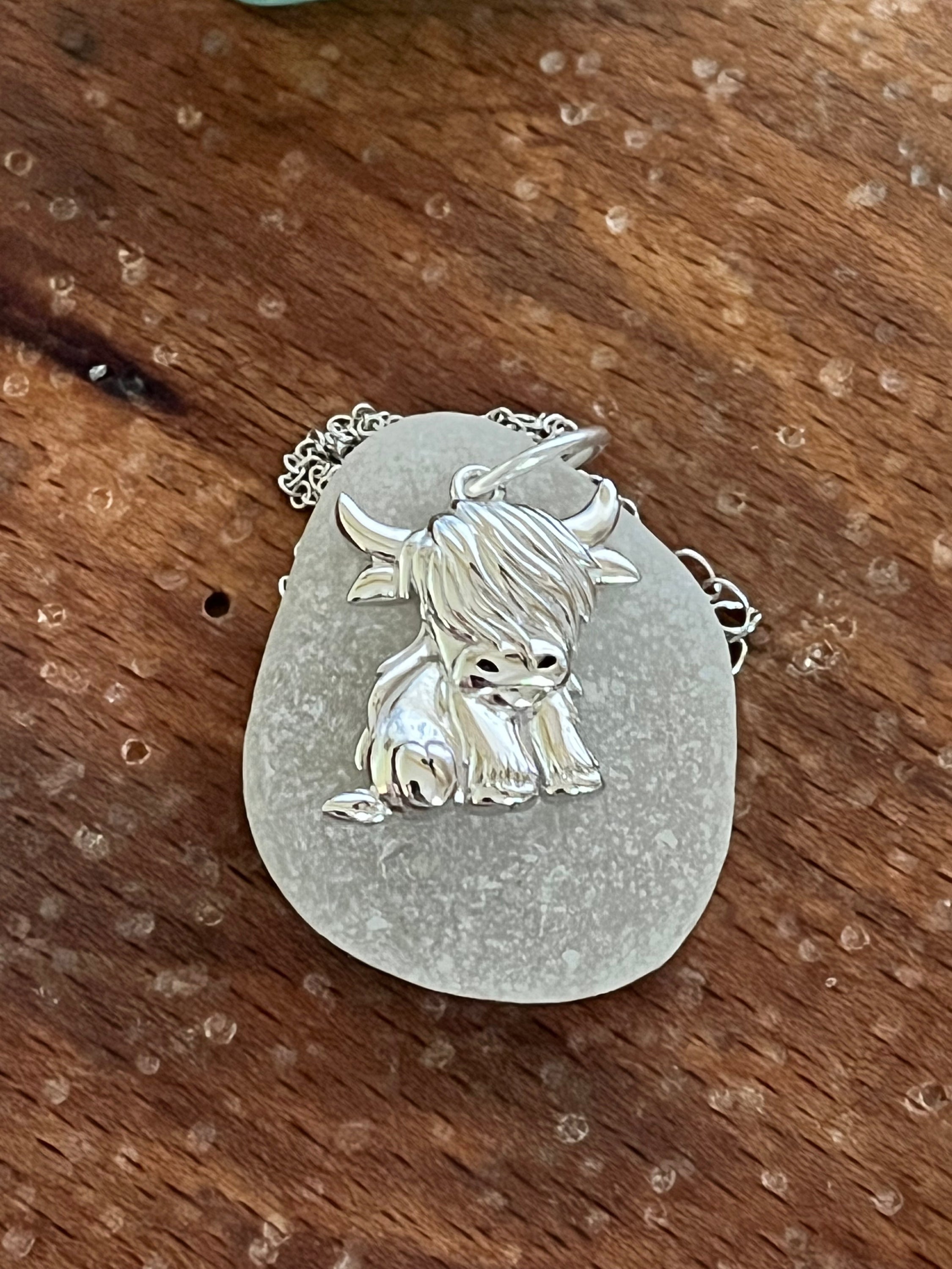 Silver highland cow 925 pendant on light gray sea glass base