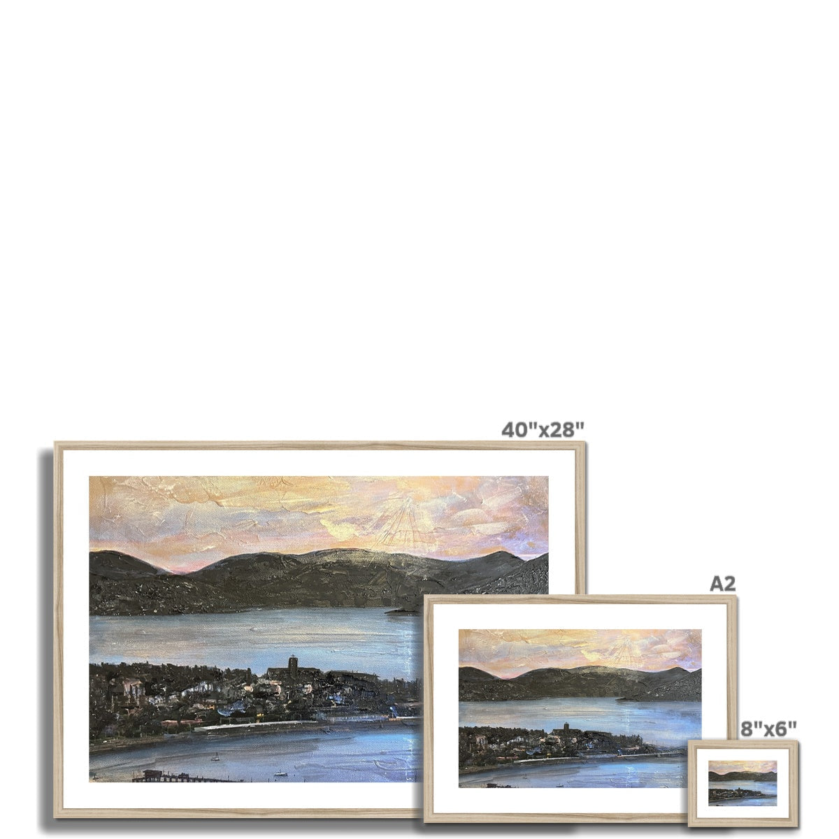 Framed landscape print of a coastal town and mountains with pastel hues, 40x28 inches
