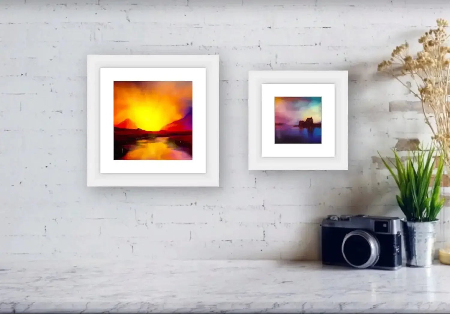 Two framed landscape paintings on textured white wall in A Moonlit Croft Scotland In Your Pocket