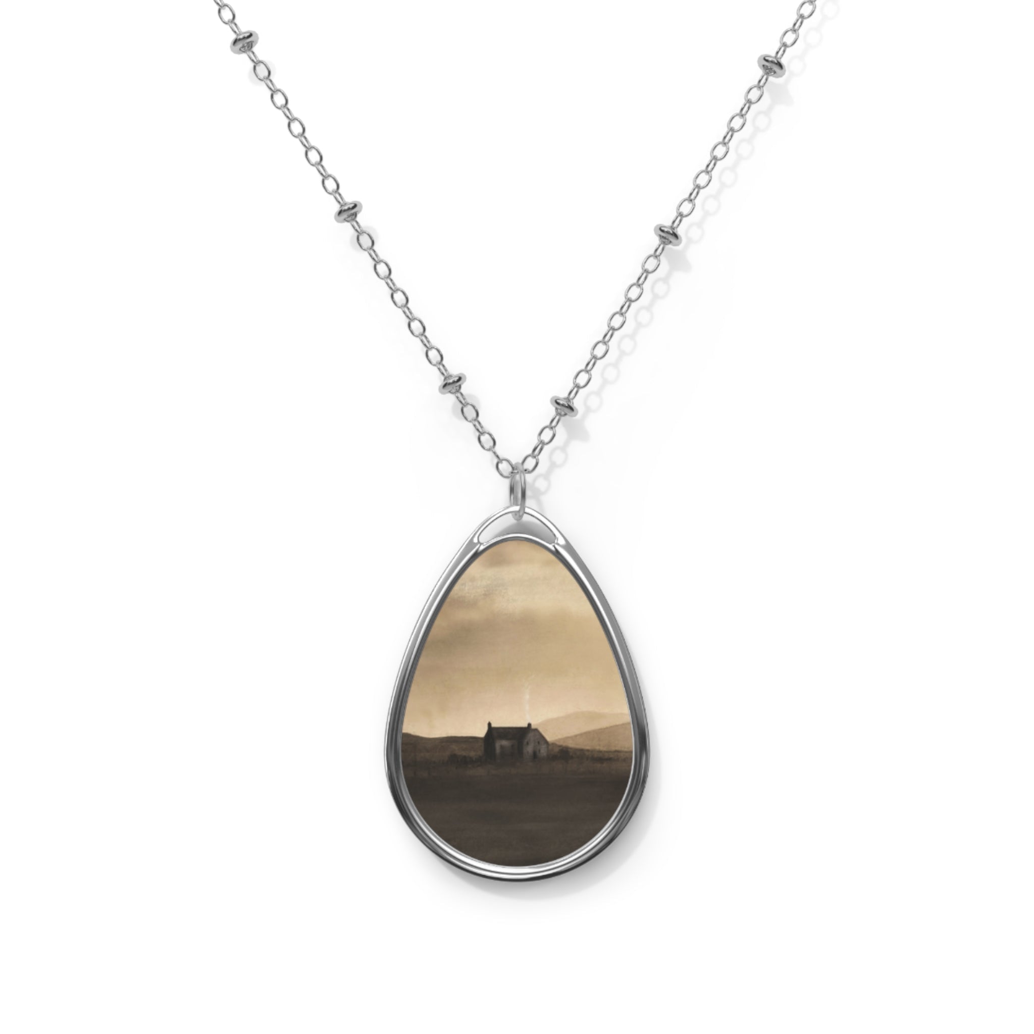 Silver chain necklace with teardrop-shaped pendant featuring a sepia-toned Scottish landscape scene