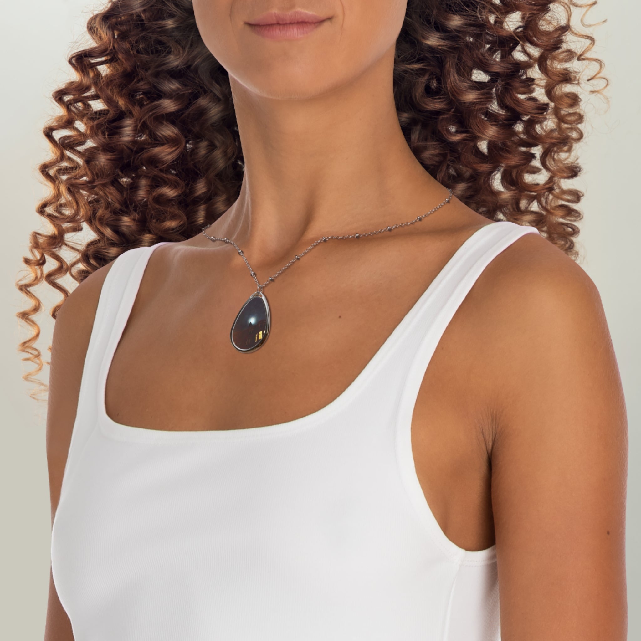 Woman wearing a white tank top and teardrop pendant necklace from A Moonlit Tenement Scottish Art Jewellery
