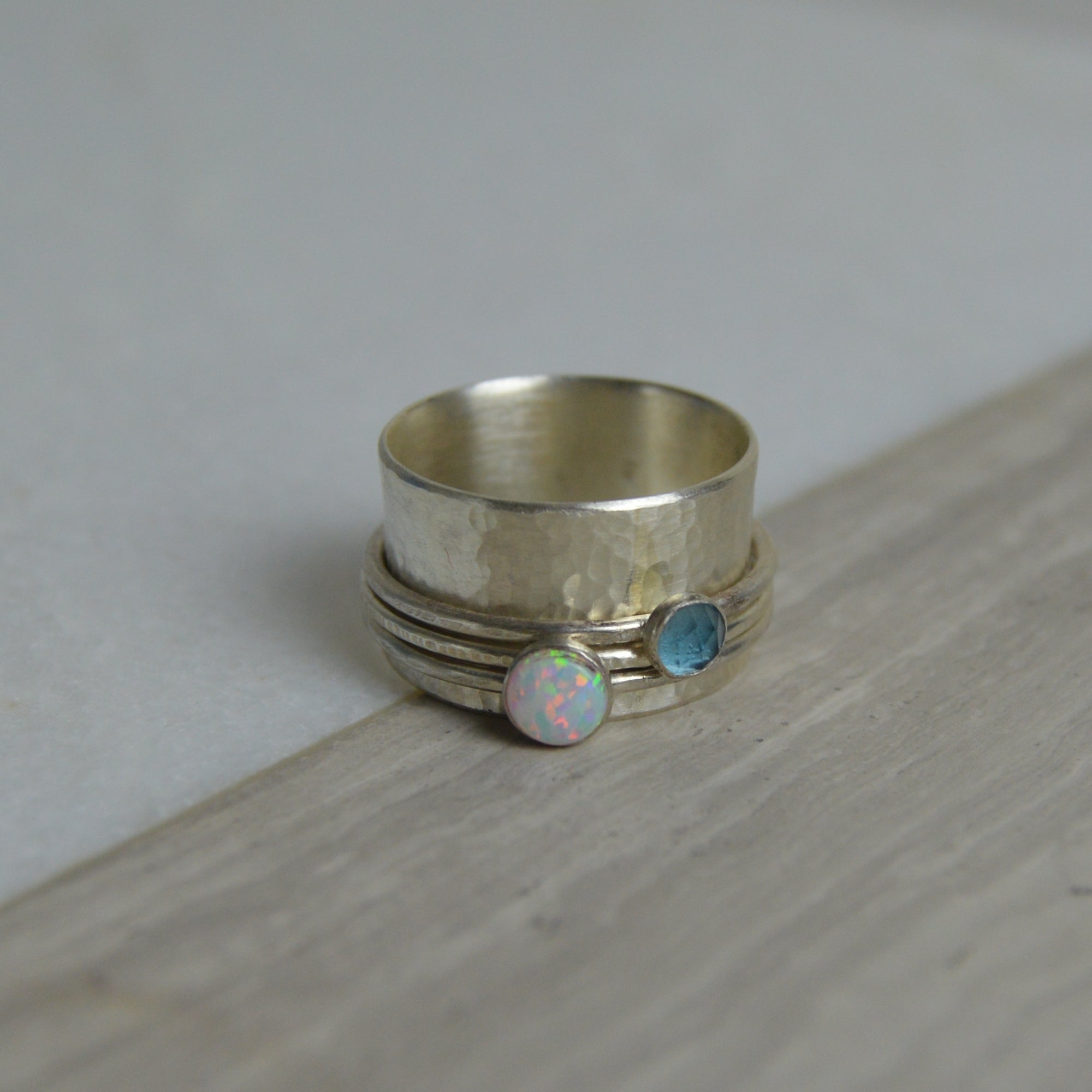 Silver-toned opal and topaz spinning ring with hammered texture and two embedded iridescent stones made to order