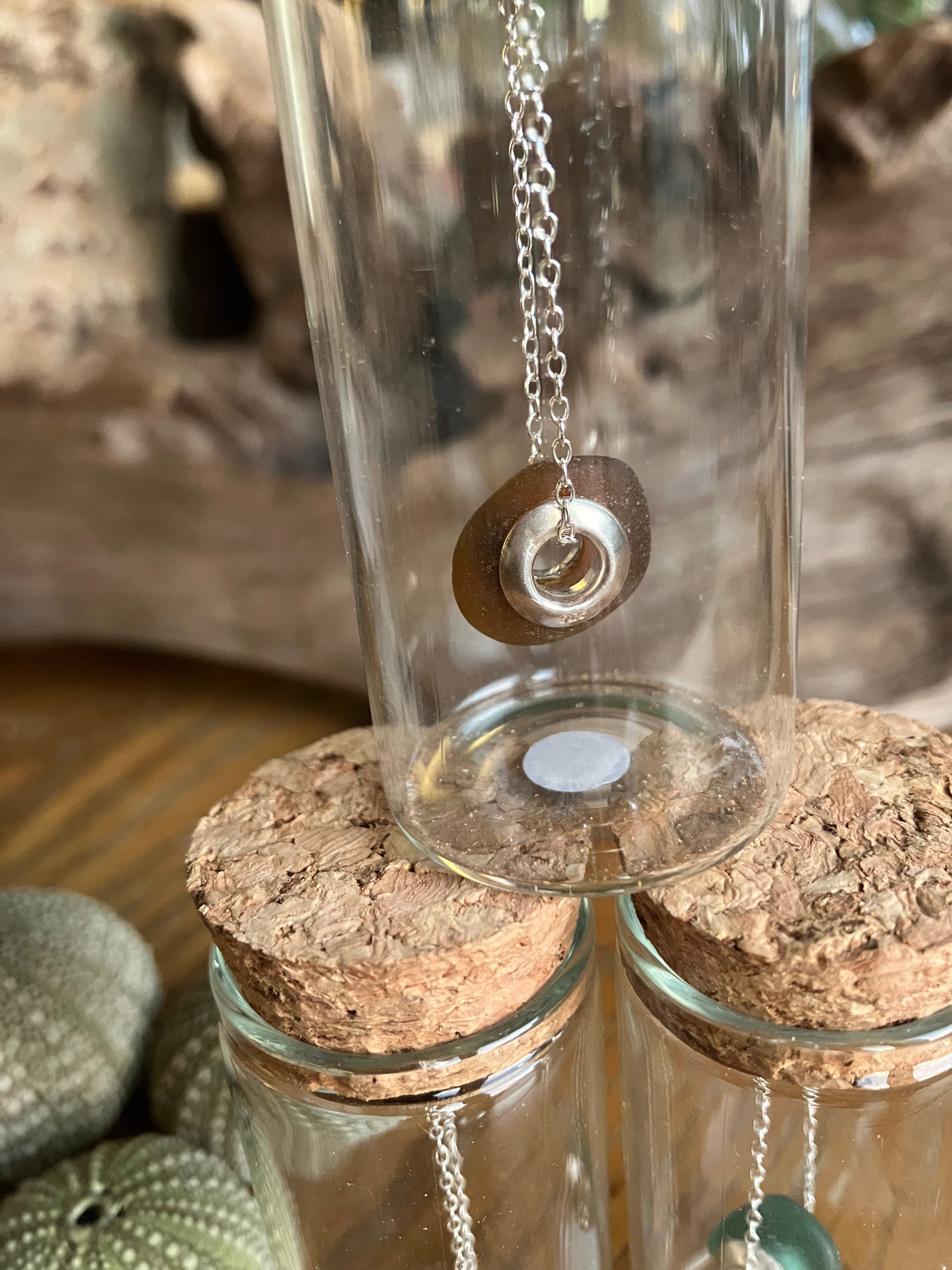 Brown sea glass pendant with silver chain and ring displayed in a glass bottle for Pandora style Seaglass Charm Bead Necklaces