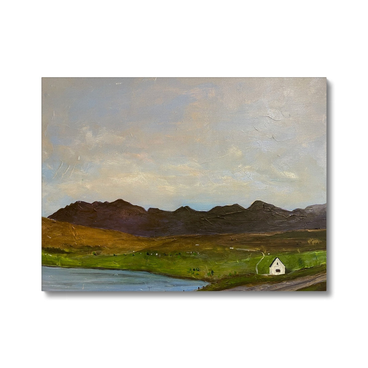 Serene landscape canvas print: dark mountains, green fields, white house by water under gray sky