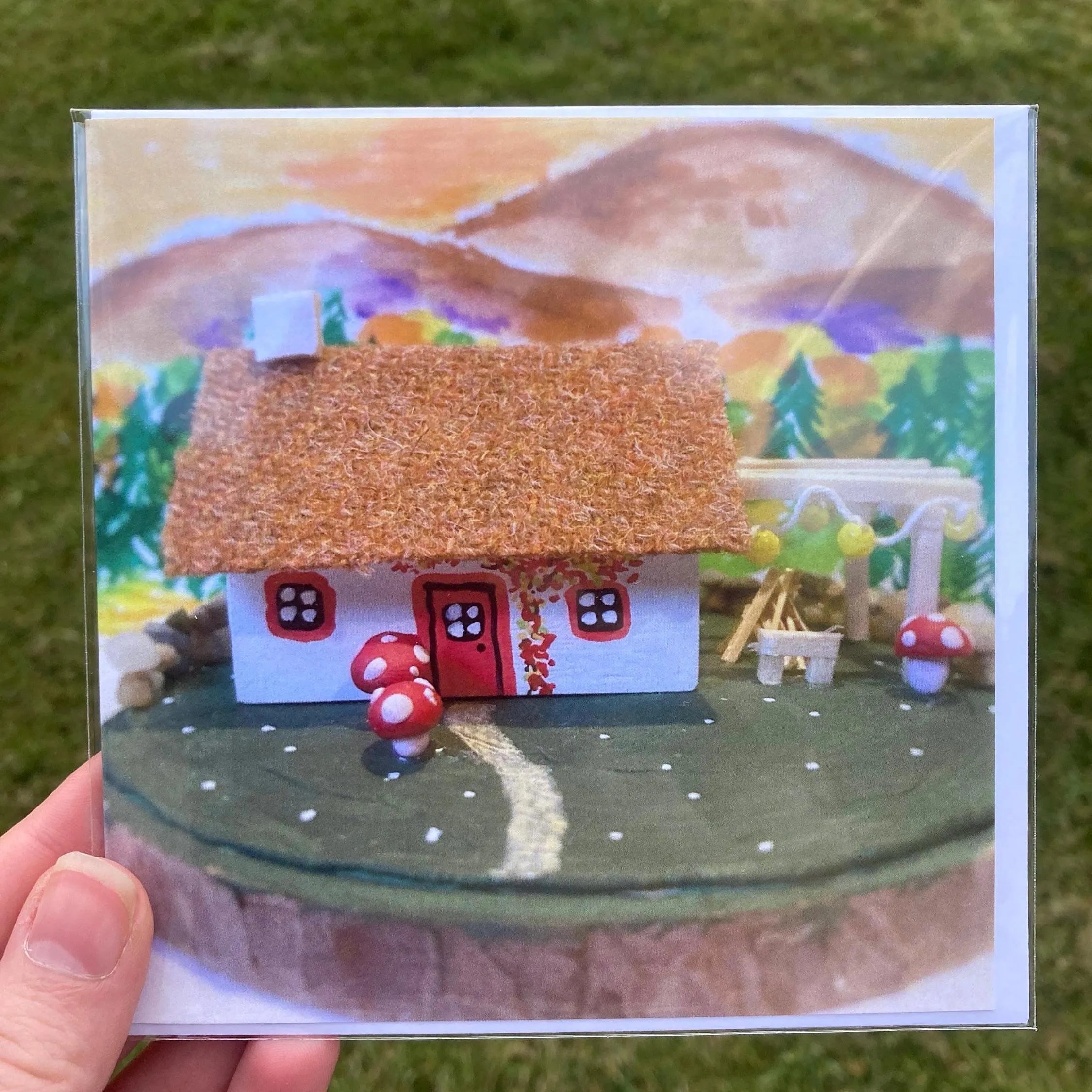 Decorative Scottish Highland Bothy with Bonfire Square Greetings Card featuring 3D cottage diorama