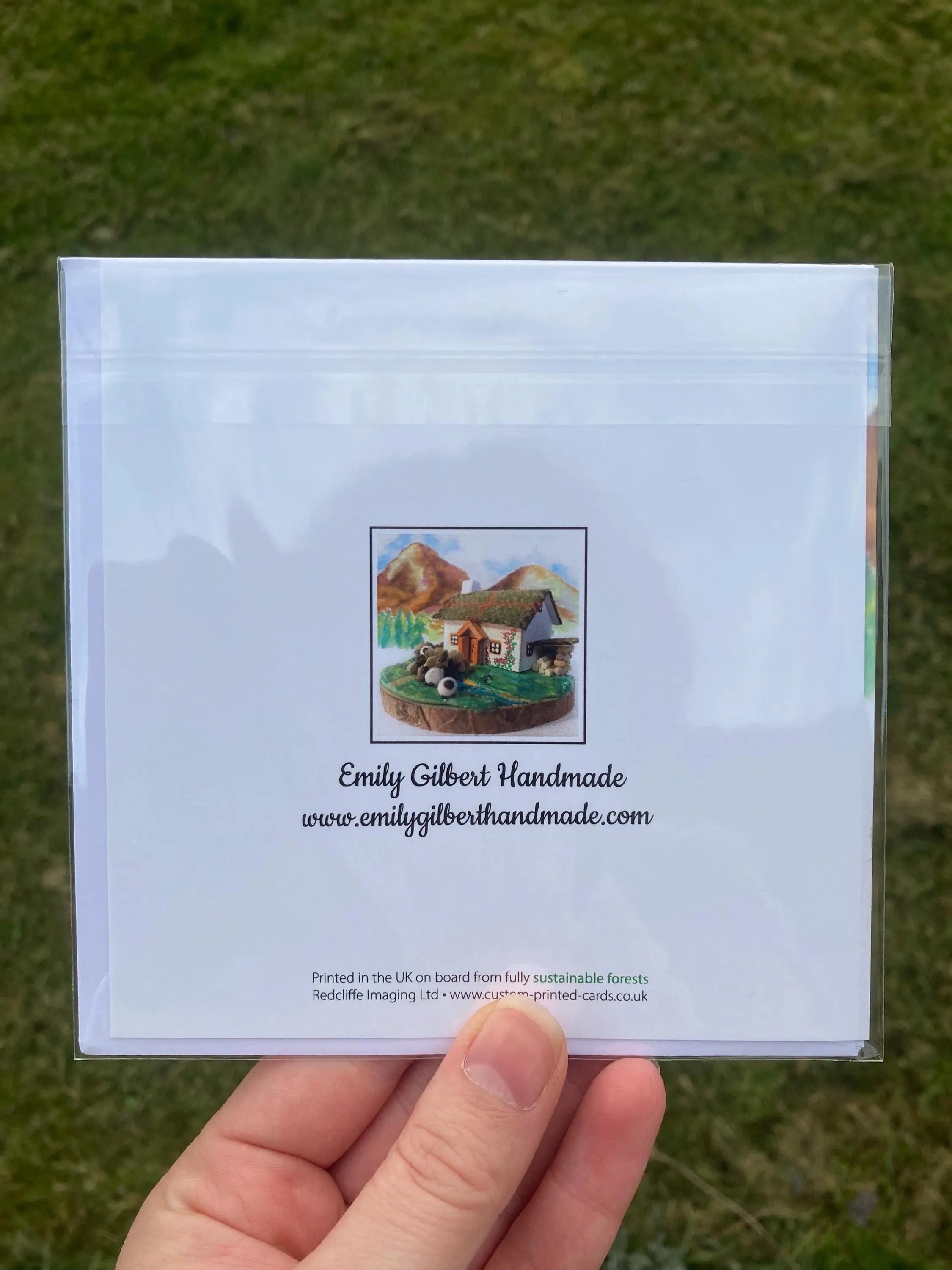 Handmade greeting card with charming farm scene illustration, packaged in clear plastic