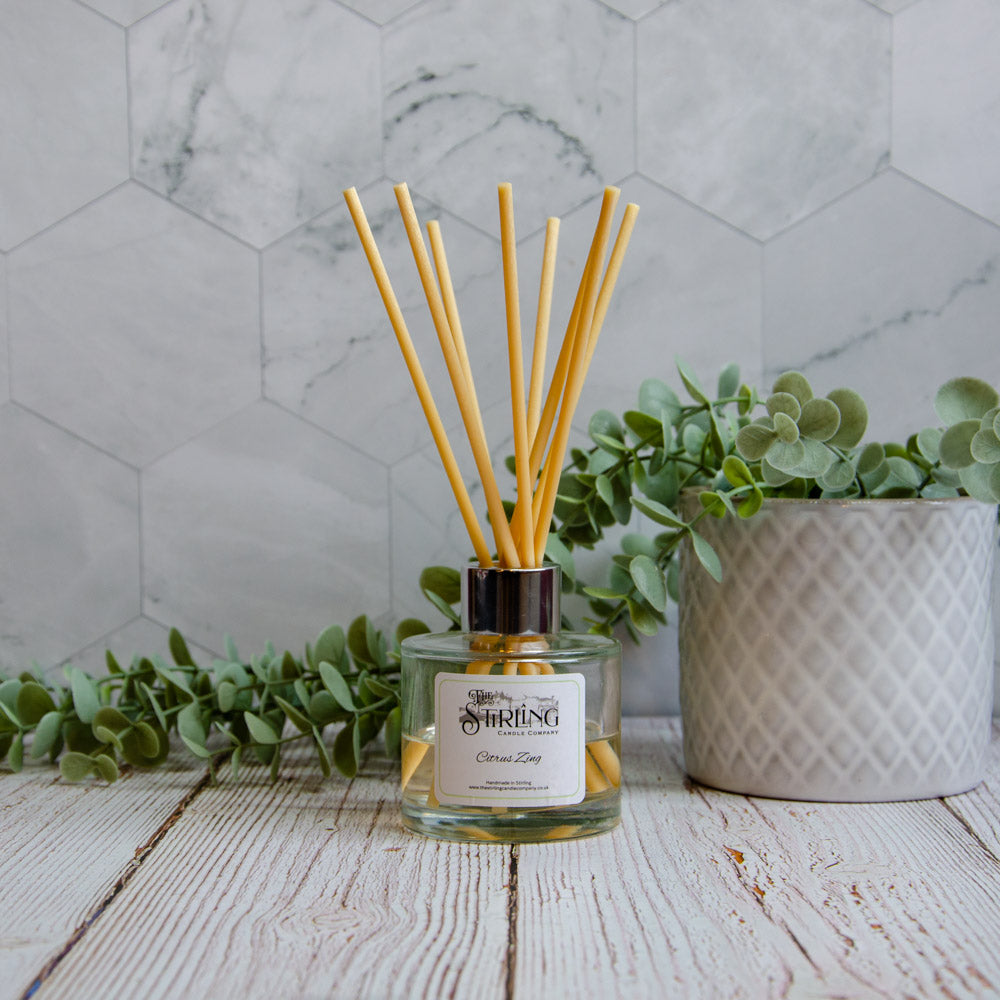 Clear glass reed diffuser with silver cap and yellow reeds labeled citrus zing by Stirling Candle Company 100ml