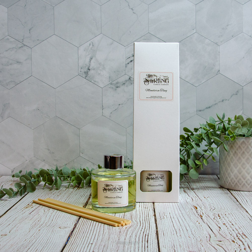 Clear glass diffuser bottle with silver cap and pale green mandarin scent liquid by Sirling Candle Company with wooden reeds