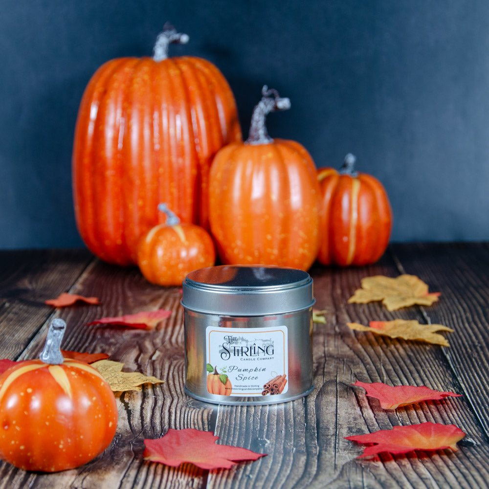Silver travel tin candle labeled pumpkin spice by the stirring candle company with festive pumpkins and spices design