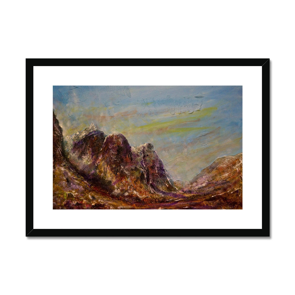 Black framed Three Sisters Glencoe art print of rocky terrain and cloudy sky