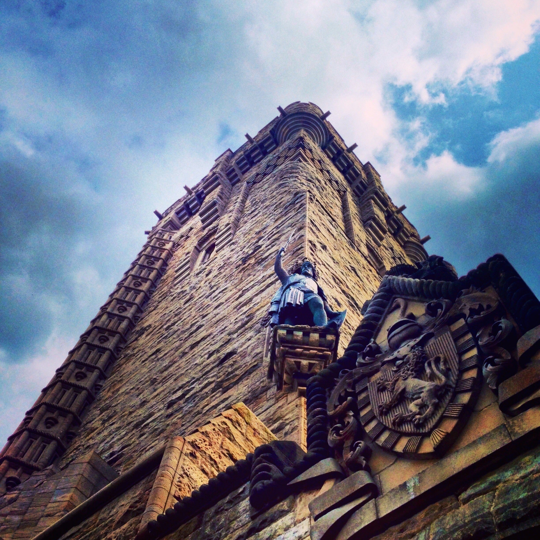 Stone tower with statue and decorative shield at The Wallace Monument in Scotland